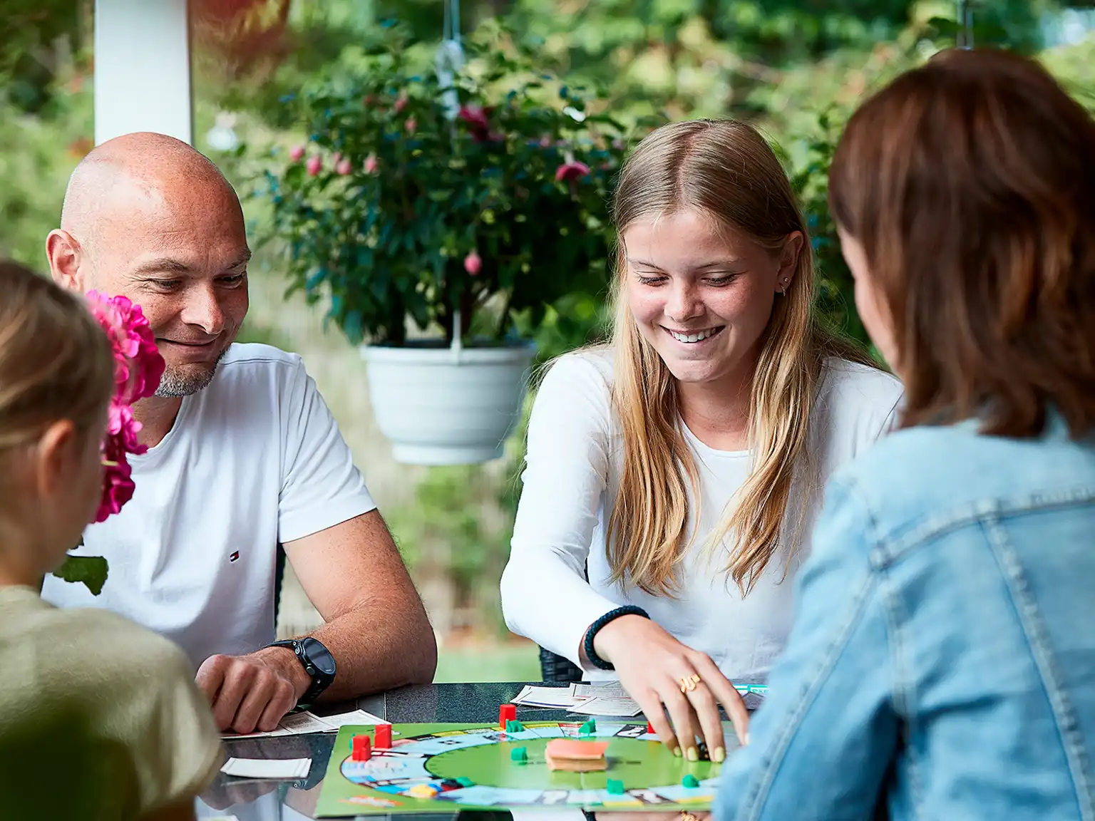 Familie der spiller brætspil og hygger sig i sommerhus