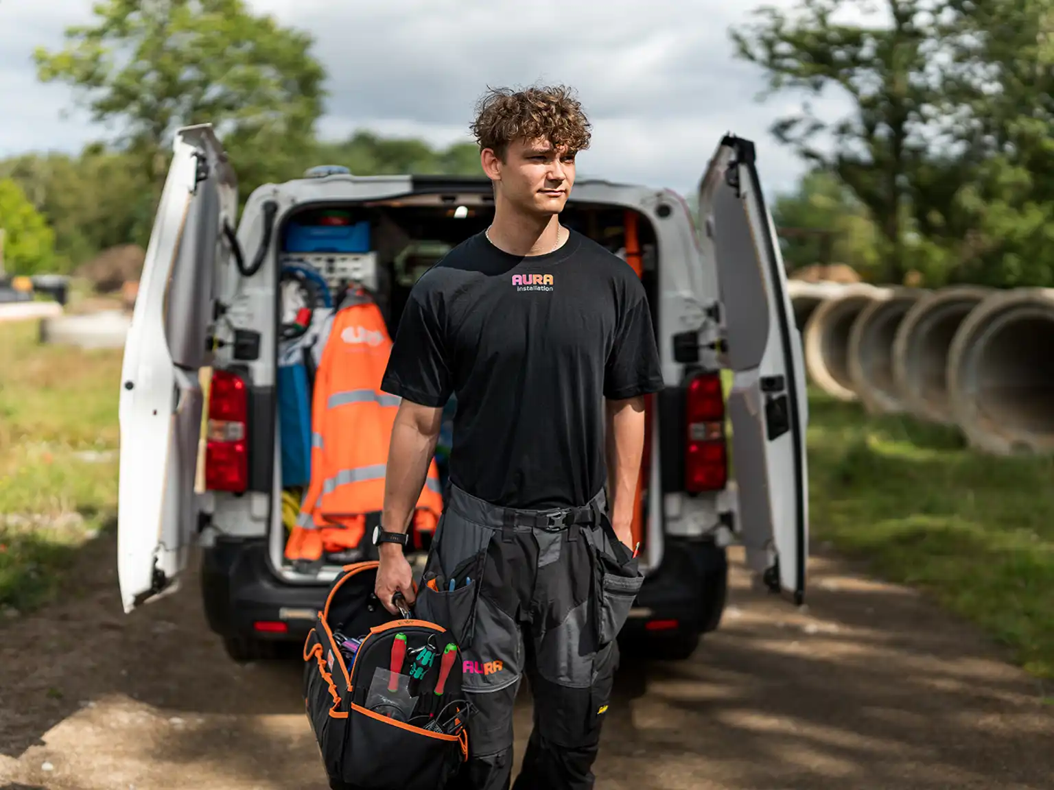 Elektriker fra AURA Installation der går med en værktøjskasse