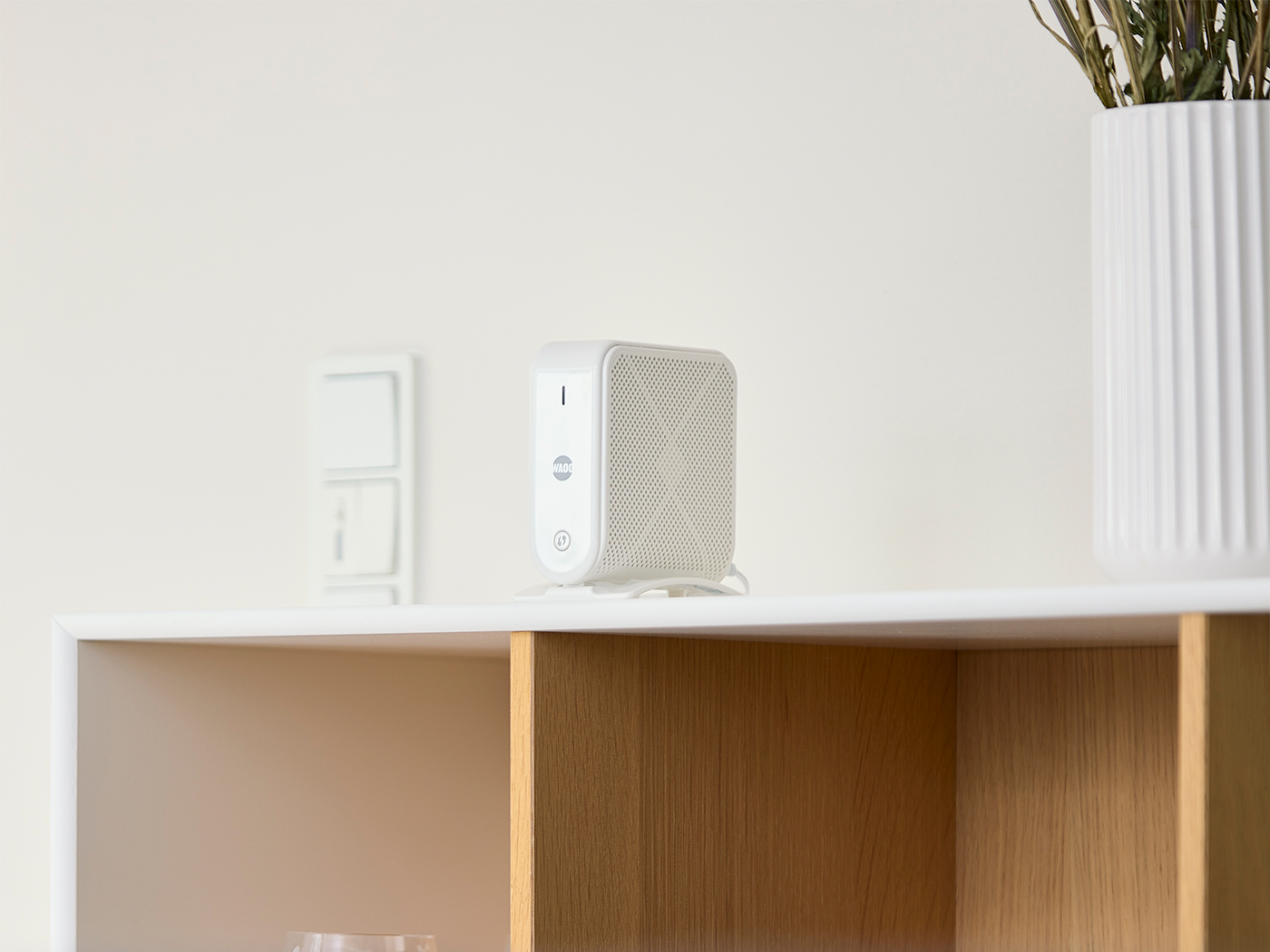 Smart wifi-enhed placeret på en reol i stuen