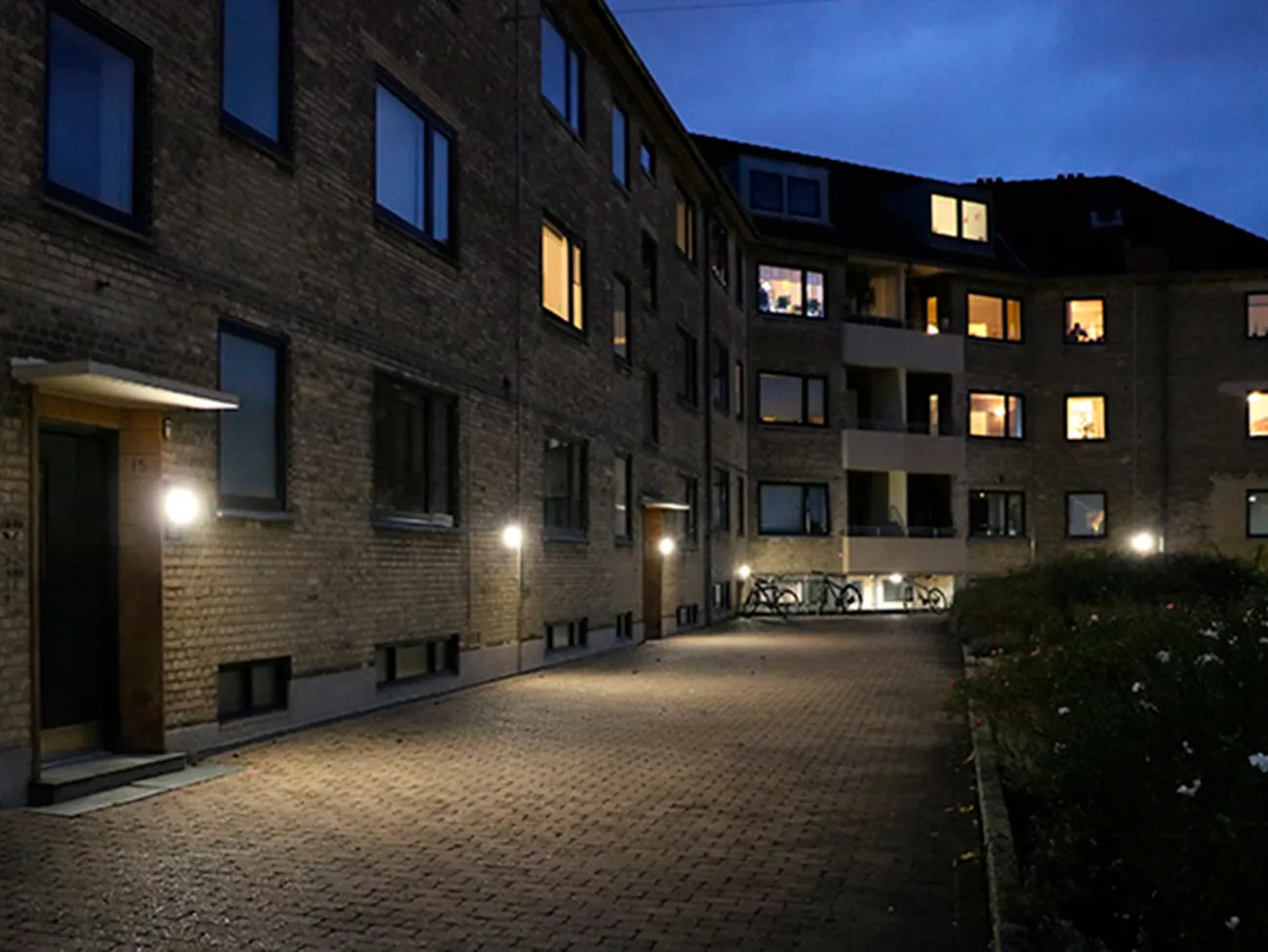 Udendørs belysning på gule murstensbygninger Viborggård