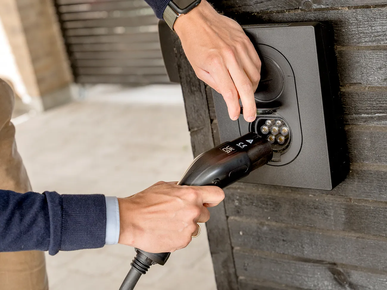 Mand der sætter ladekabel i sin ladeboks til elbil