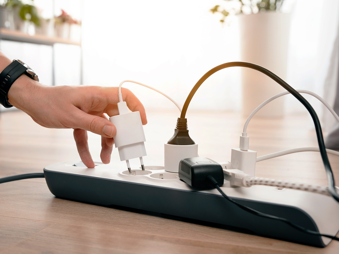 Mand sætter nyt stik i elspareskinne som ligger på gulvet