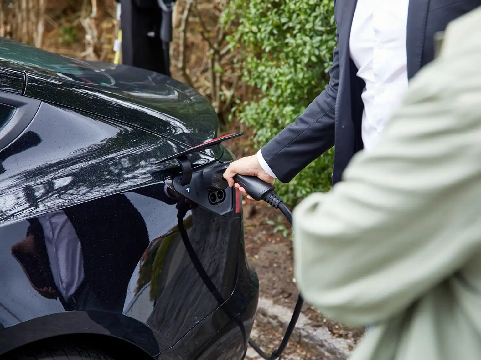 Mand sætter elbil til opladning med firmabilsløsning