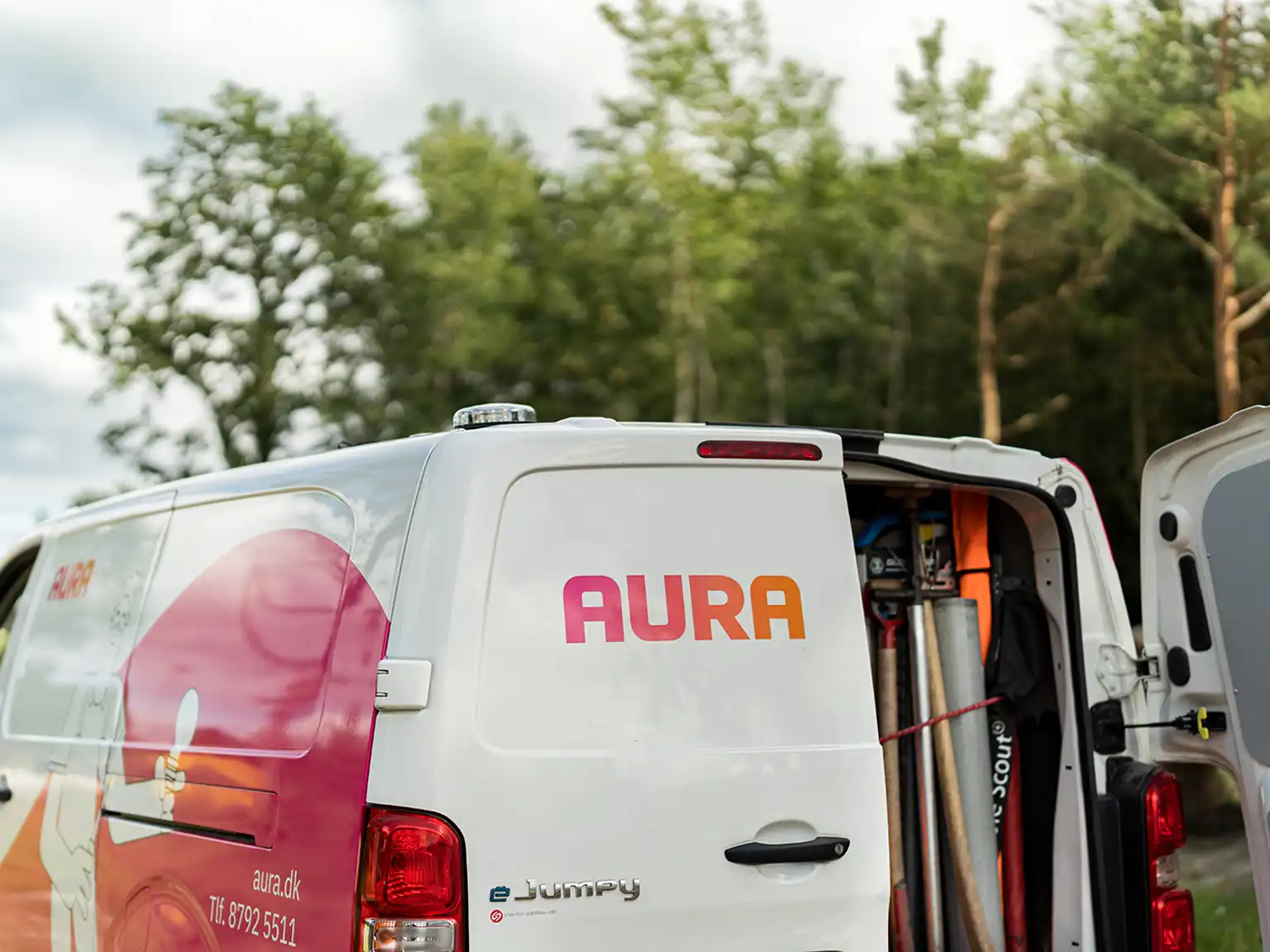 AURA bil der står åben med redskaber og materialer