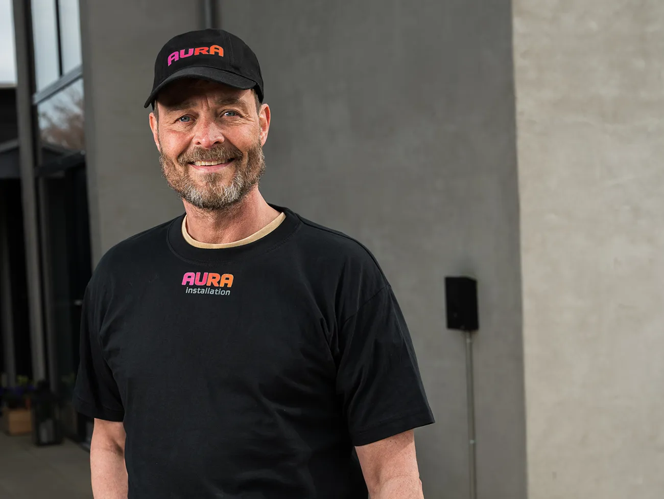Installatør fra AURA Installation der står og smiler