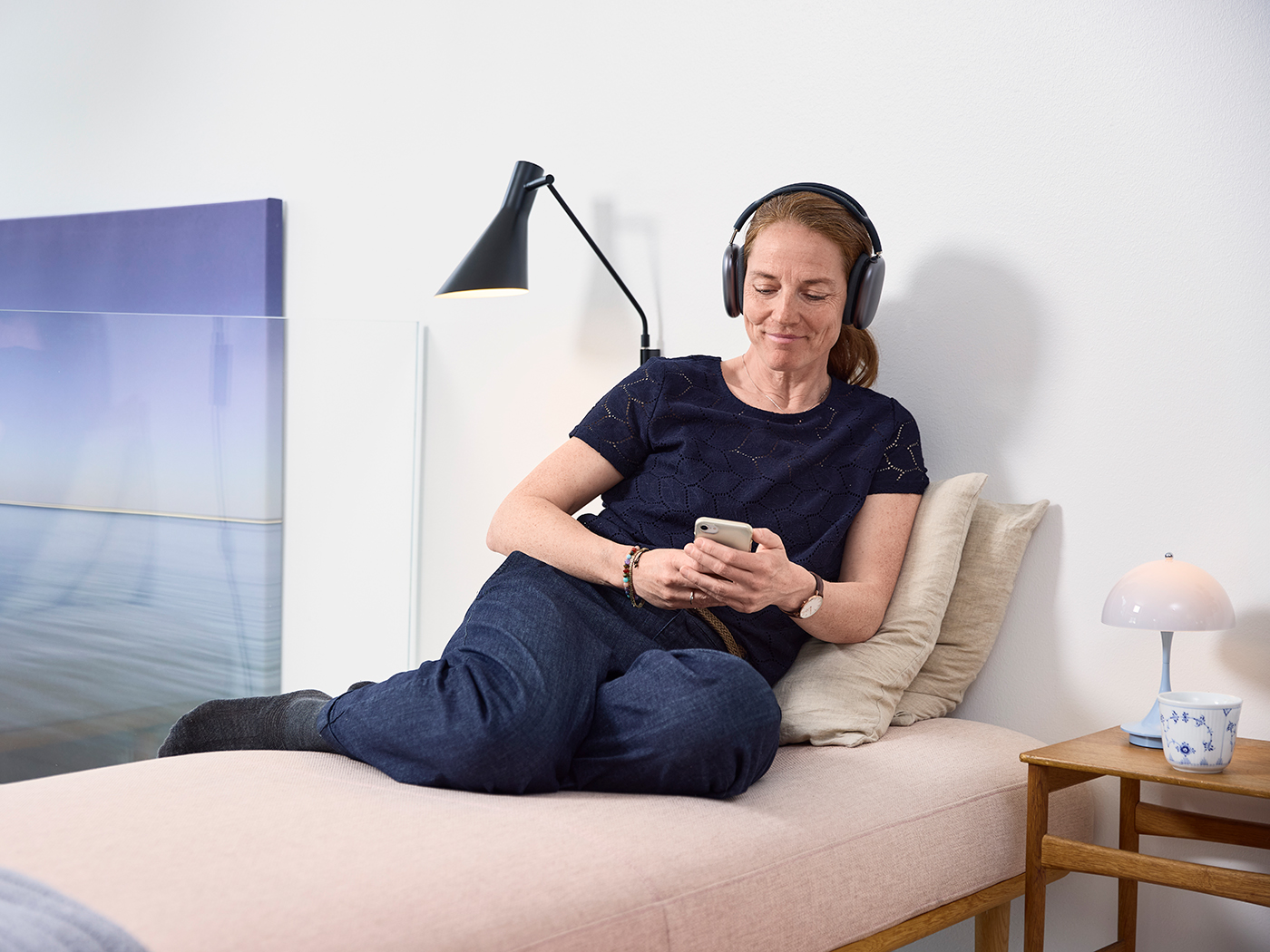 Kvinde slapper af med mobil og høretelefoner