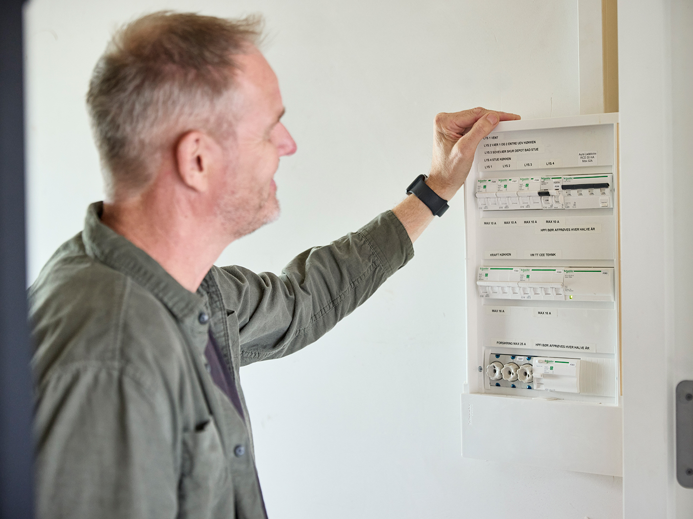 Mand står og kigger på husets eltavle