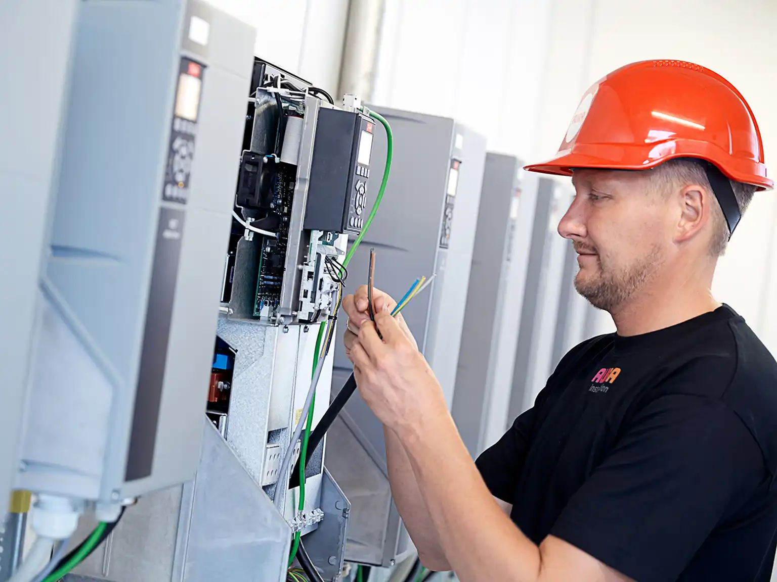 Elektriker står med ledning fra eltavle og kigger på lederne