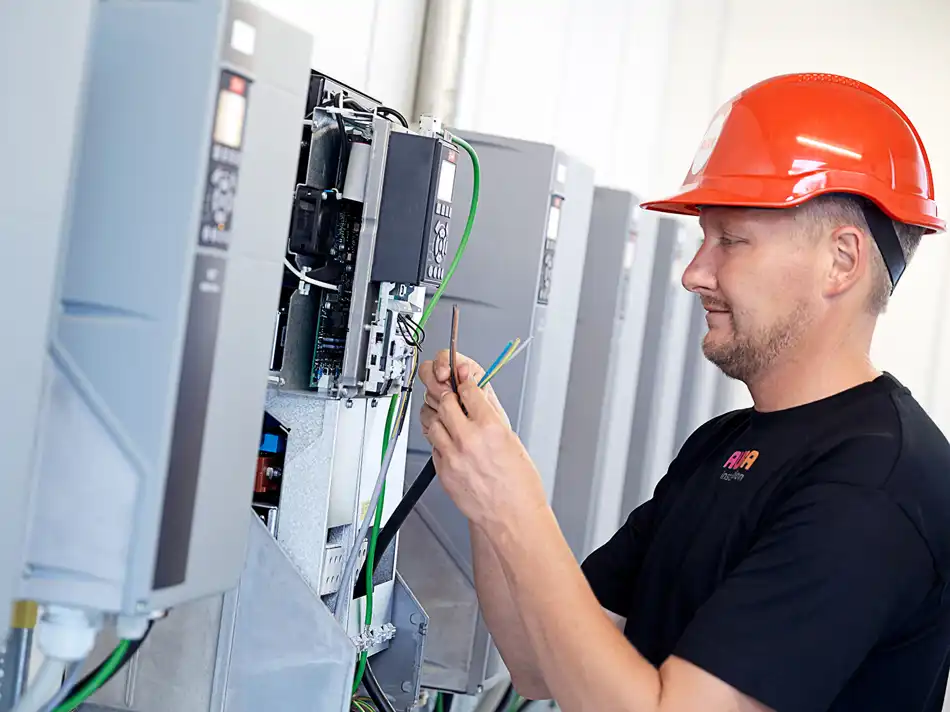 Elektriker står med ledning fra eltavle og kigger på lederne