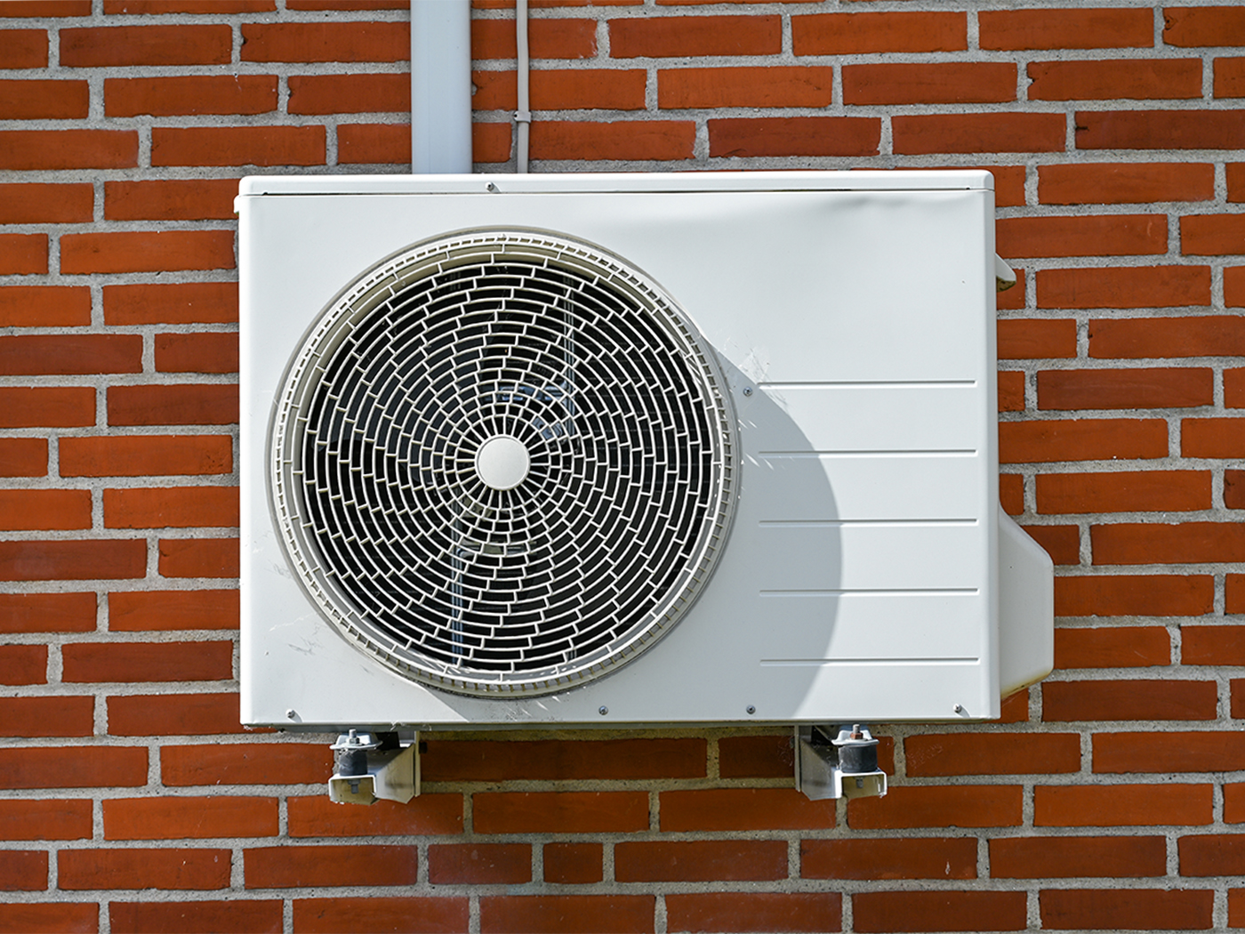 Varmepumpe monteret på rød murstensvæg