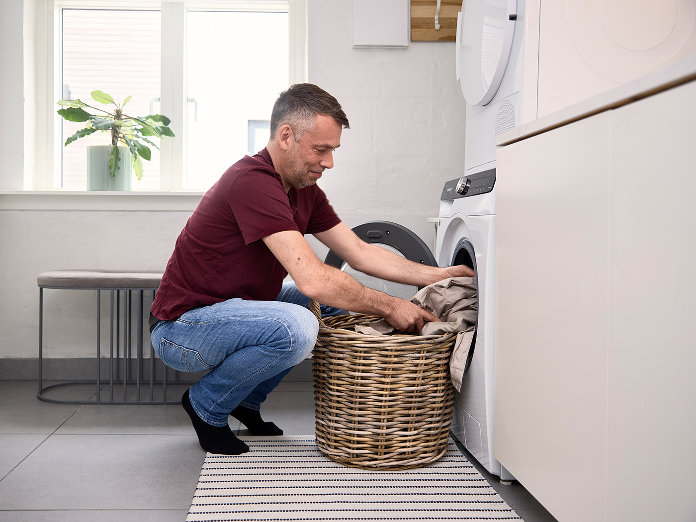 Mand fylder vaskemaskine med lagner