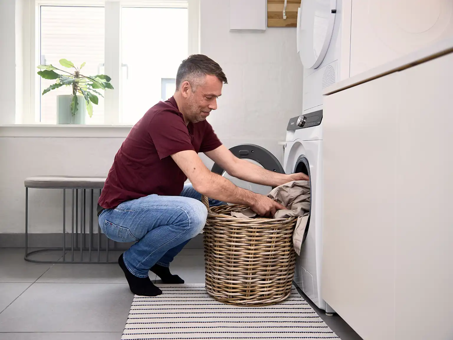 Mand fylder vaskemaskine med lagner