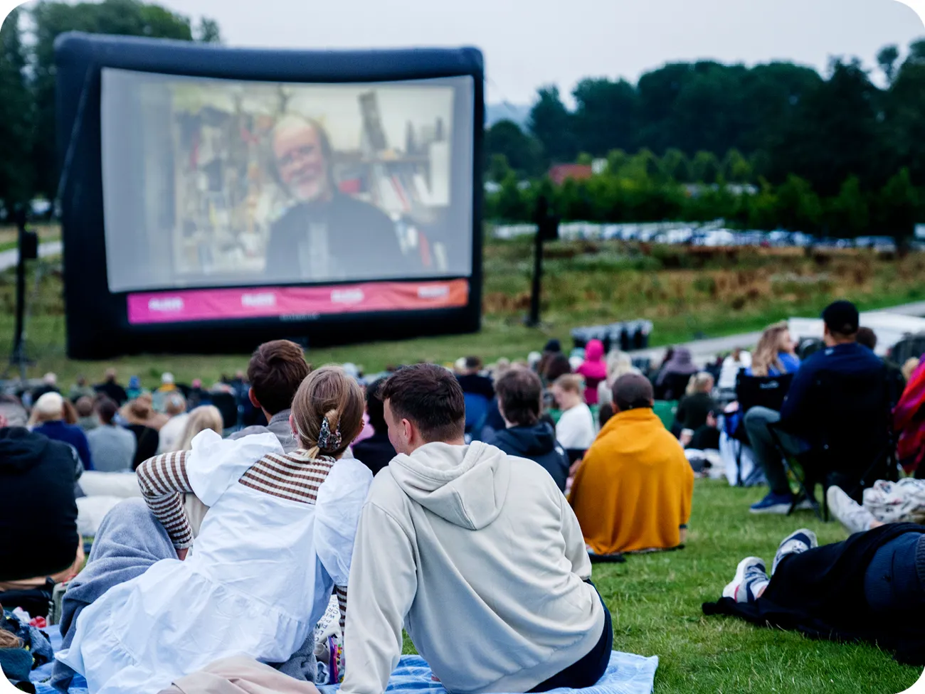 Sommerbio gæster ser film på tæppe på Moesgaards tag