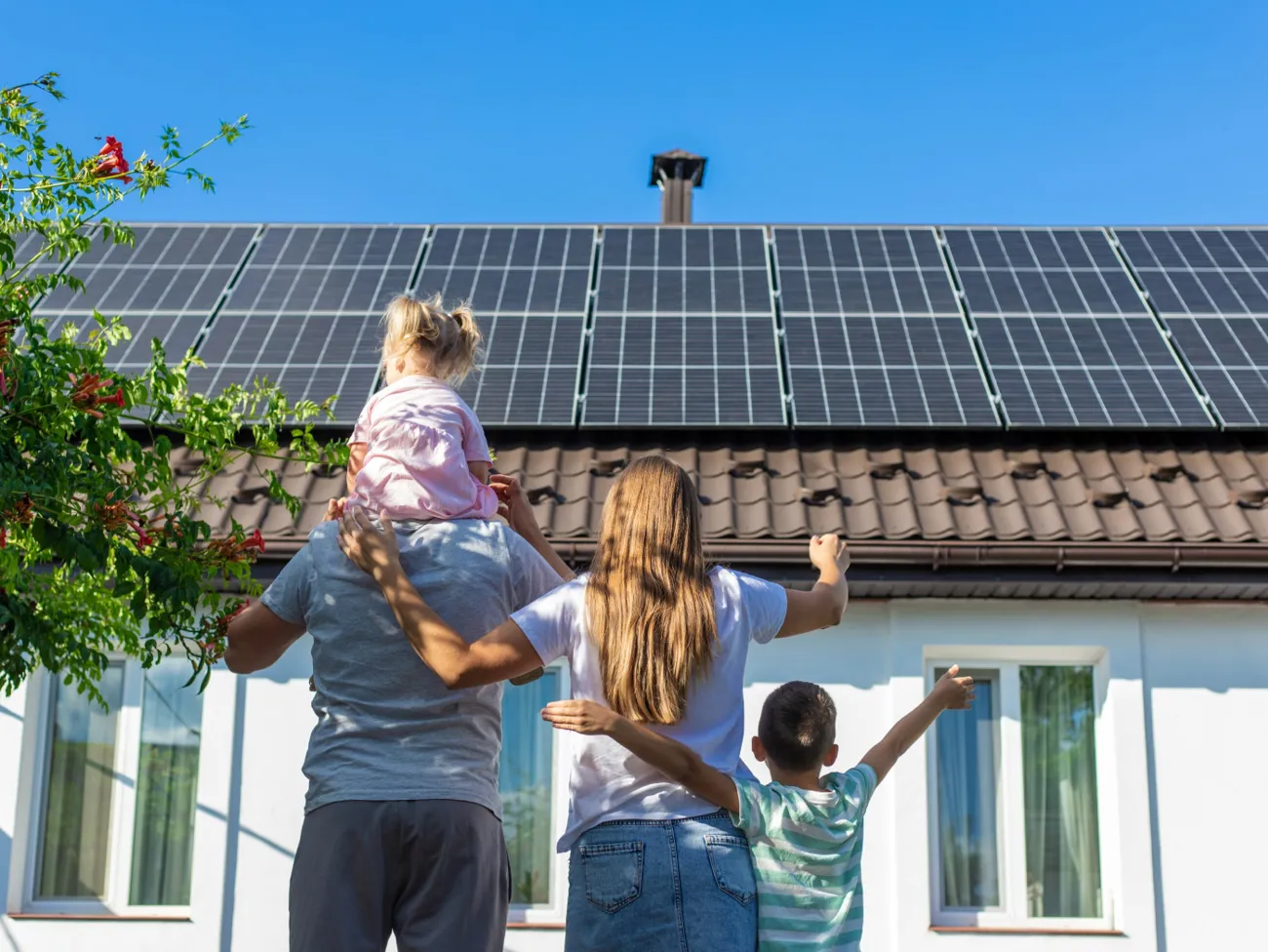 familie-solceller Familie står med ryggen til og kigger på solceller