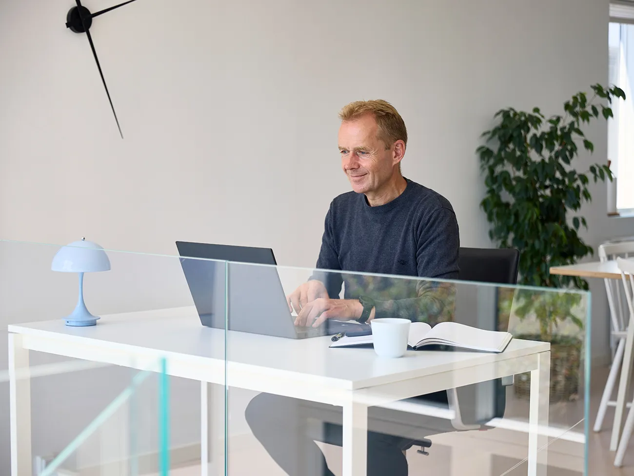 Mand sidder ved skrivebord og taster på sin computer