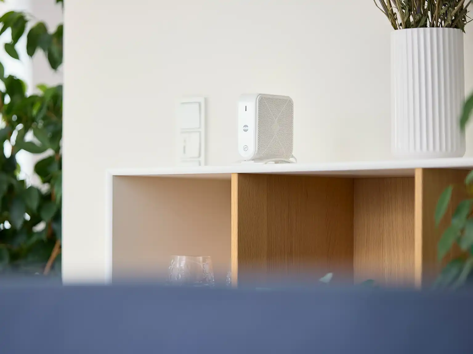 Smart wifi-enhed placeret på en reol i stuen for at sikre optimal dækning i hele hjemmet