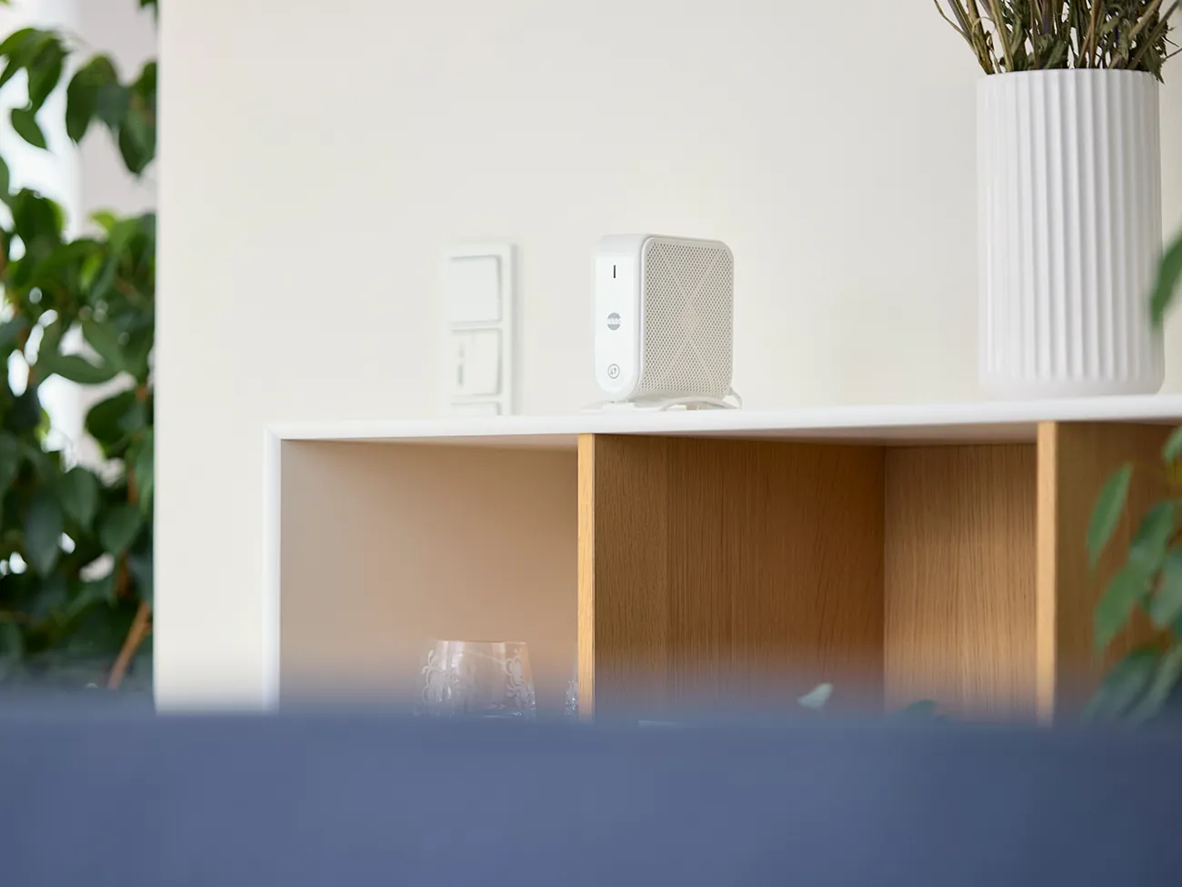 Smart wifi-enhed placeret på en reol i stuen for at sikre optimal dækning i hele hjemmet