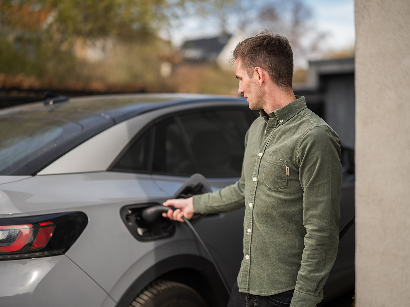 Mand der sætter ladekablet i sin elbil