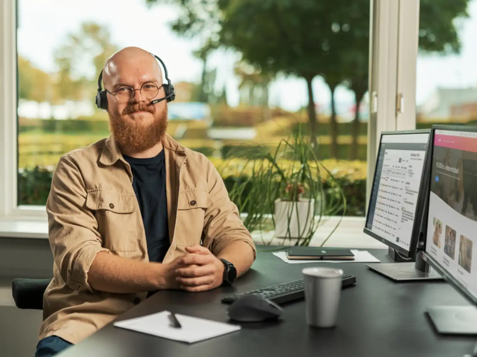 kundeservice-mand-med-headset Mand med headset sidder foran en computer