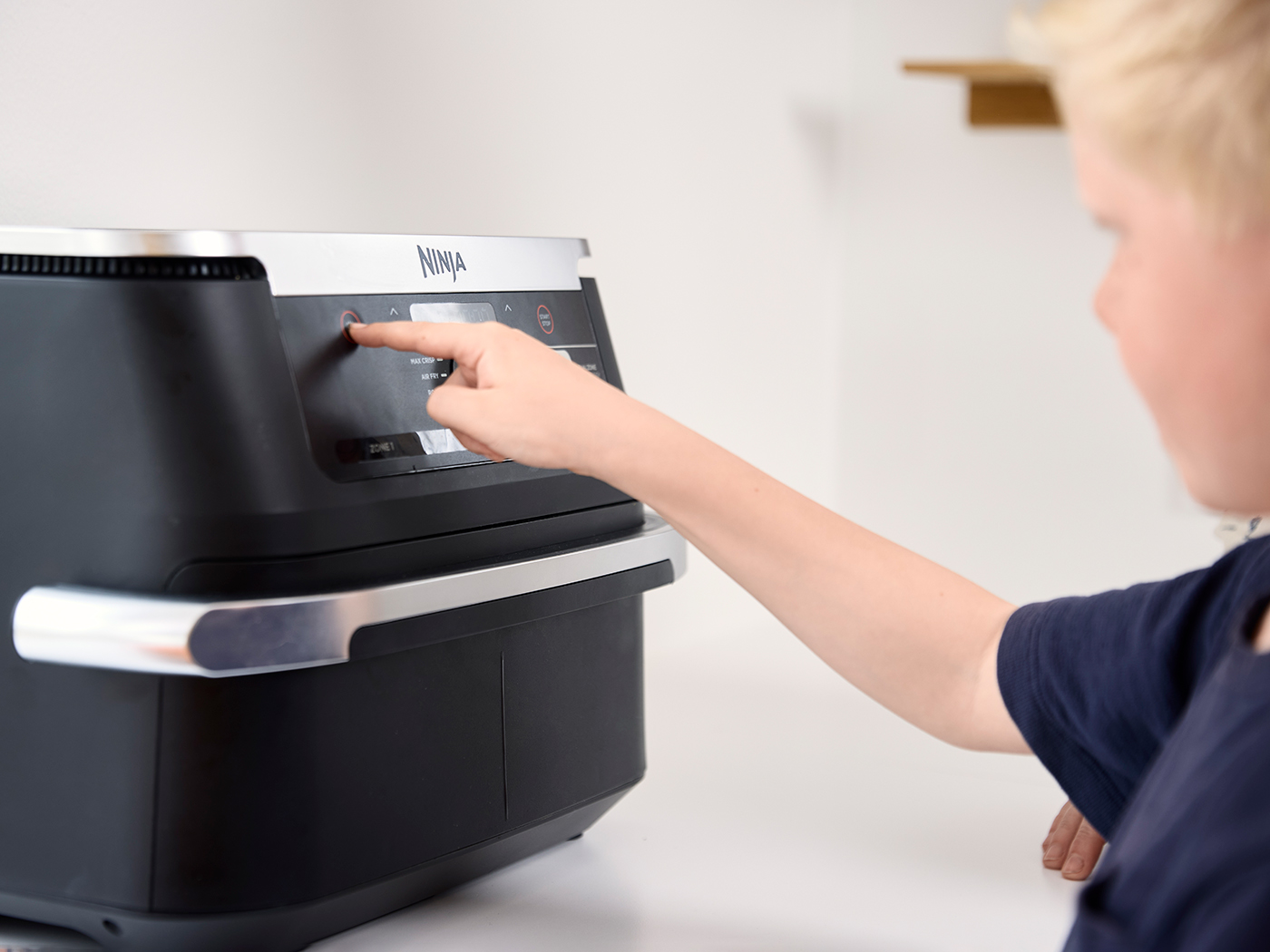 Dreng indstiller airfryer til at lave mad