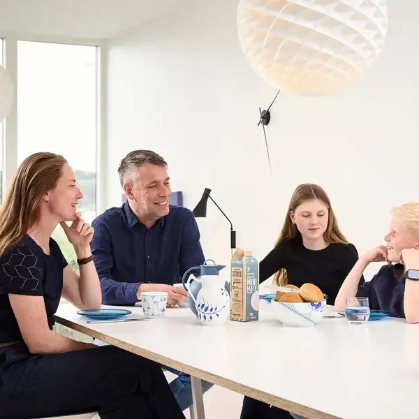 Familie sidder sammen og taler over morgenmaden