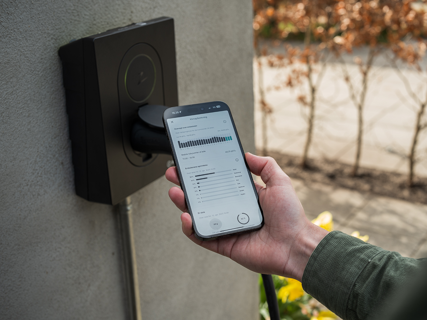 Mobil med ladeapp Spirii Go holdes foran en ladeboks