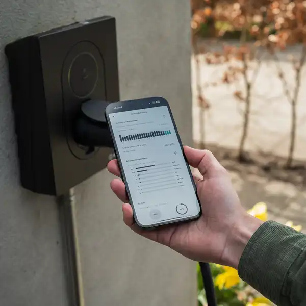 Mobil med ladeapp Spirii Go holdes foran en ladeboks